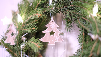 A close-up view of a festive Christmas wreath, adorned with charming wooden Christmas tree ornaments.