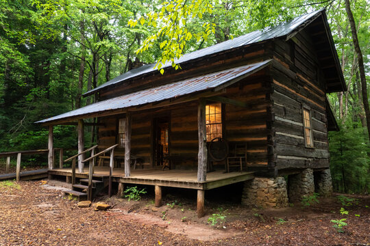 A log cabin in the woods with lighted windows