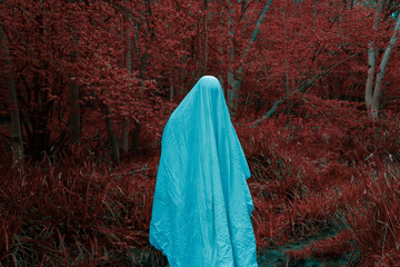 a vaporwave, infrared edit. Of horror concept of a ghost in a sheet. Standing in a red spooky forest.