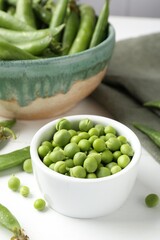 Fresh ripe green peas on white wooden table, closeup