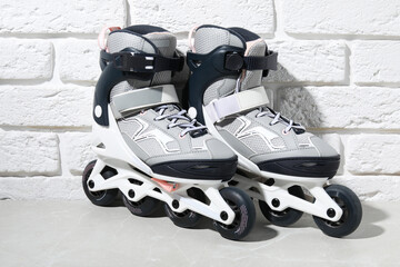 Pair of roller skates on grey marble table near white brick wall