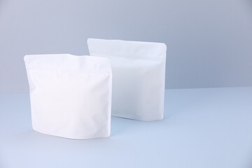 Two zipper stand-up pouches on light grey background. Mockup for design