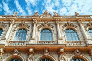 Obraz premium ornate classical building facade with arched windows and intricate stone carvings under a bright blue sky with scattered clouds