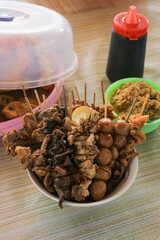 Many kinds of satay on a bowl, side dishes for Soto Ayam. Egg satay, chicken heart satay, and chicken satay. Indonesian dish.