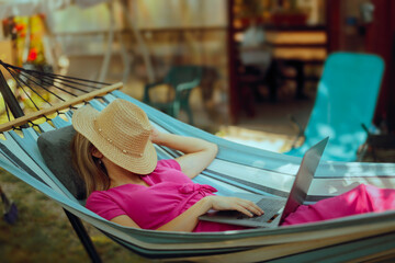 Carefree Woman On Vacation in a Hammock resting with laptop. Happy resting lady on vacation feeling lazy trying to work remote
