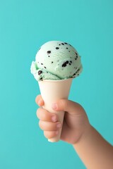 Childs hand holding mint ice cream cone. (10)