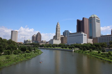 Clean and modern urban skyline of downtown Columbus, Ohio, showcasing architectural diversity, city life, and metropolitan identity. A blend of contemporary and historic buildings under clear skies.