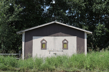 An old and small rural cabin with little windows. Rustic and rural architecture. Ancient and old...