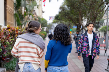 Naklejka premium Two friends walking and looking at passing boy in urban setting