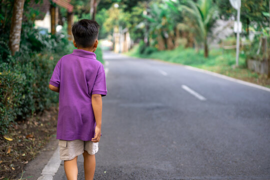 Child walking alone in a city park on a very sunny day. High quality photo