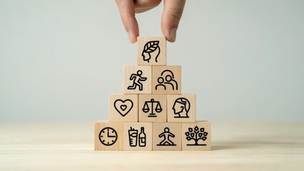 Hand places mindful living block atop pyramid of wellness icons, promoting balance and health