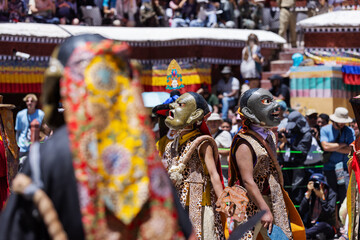 Masked dancers in dramatic expressions perform ritualistic Cham dances during the Hemis Festival in Ladakh, captivating the audience with their vibrant costumes and symbolic Buddhist storytelling.