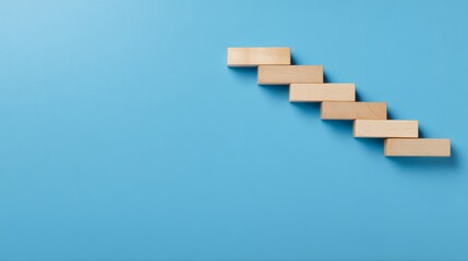 Obraz premium The wooden blocks are arranged in the form of stairs on the blue ground, the steps to business success, the concept of success