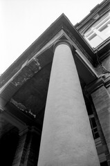 Analog vintage monochrome photography of a concrete column supporting a building
