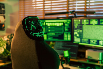 In a dimly lit cyber lair, a glowing hacker mask watches over a desk as encrypted code streams...