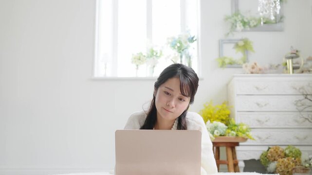 ノートパソコン、女性、PC、悩む、悩み、考える、疑問、不満、不安、心配、寝る、寝転ぶ、リラックス、室内、部屋、日本人、若い、20代、困る、憂鬱、ニュース、フェイクニュース、記事、web、インターネット、オンライン、DX、仕事、相談、カジュアル、インテリア、動画、検討、想像、コピースペース、おしゃれ、イライラ、見上げる、かわいい、美人、美容、スキンケア、買い物、ネットショッピング、迷う、難しい、スロ