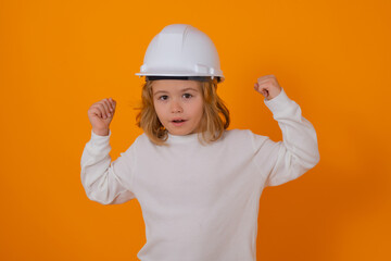 Child in builder uniform with hardhat. Happy kid wearing helmet posing as engineer. Kid handyman. Child construction worker. Kid playing builder. Child posing in repairman outfit.