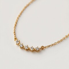 Fototapeta premium Close up shot of a delicate gold chain necklace adorned with five small sparkling diamond accents on white