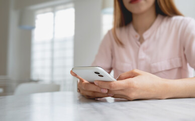 Woman using smartphone with background in home. Social network and wireless technology concept.