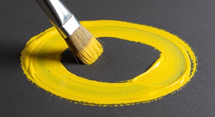 Yellow paint circle on dark gray background with paintbrush