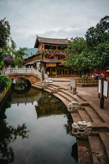 Fototapeta premium Riverside pavilion with stone bridge in Lijiang Old Town, China