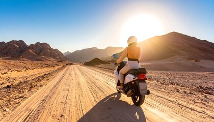 Woman riding scooter on desert road toward sun and mountains with travel adventure.