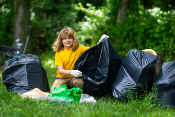 Child boy picking up plastic bottle outdoor. Save environmental and reduce waste concept. Recycle...