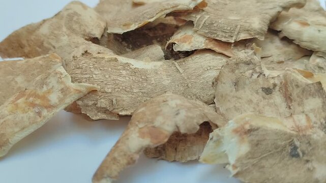 Cassava peel on a white background. Cassava peel has a variety of potential uses, including being converted into animal feed, compost, or a source of bioenergy.