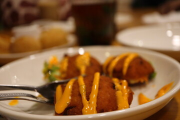 Close-up of Crispy South Indian Vadai with Spicy Mayo Drizzle on a White Plate – Traditional Deep-Fried Fritter Appetizer Served Fresh with Cutlery on a Restaurant Table – Authentic Indian Cuisine