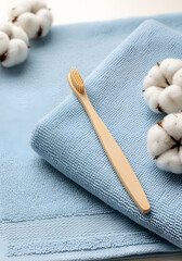 Fototapeta premium Eco-Friendly Bamboo Toothbrush on Soft Towel with Cotton Balls