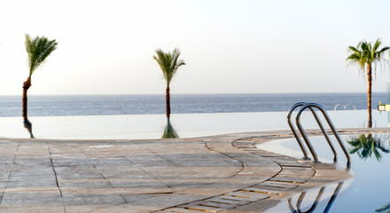 Beautiful swimming pool by the sea at sunrise