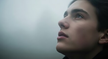 Fototapeta premium Close-Up of Young Man Looking Up in Fog with Visible Breath