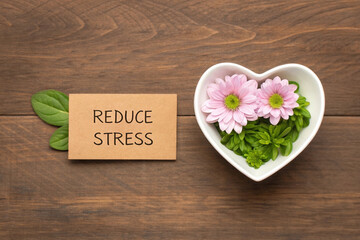 Reduce Stress Concept with Flowers and Greenery in Heart Shaped Bowl on Wooden Table for Wellbeing
