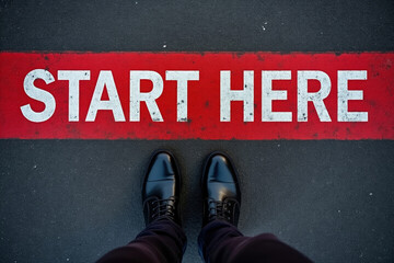 Start Here Concept with Black Shoes on Asphalt Road and Red Stripe Encouraging Action and New Beginnings