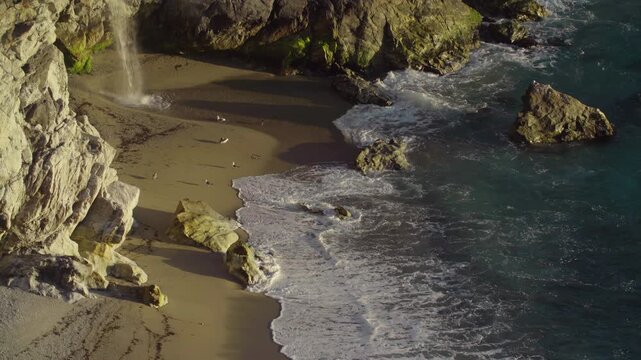 McWay Falls tumbles onto the beach at Julia Pfeiffer Burns State Park. The waterfall is a popular tourist destination in Big Sur, California, USA.