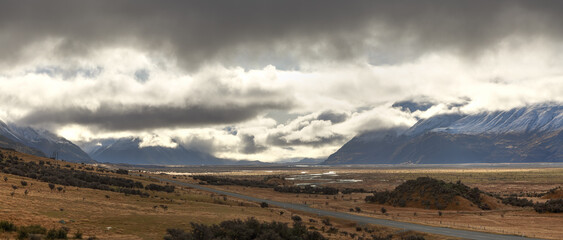Panoramic view of the Tasman River Valley in Mount Cook National Park, New Zealand, with sunlight breaking through the clouds 