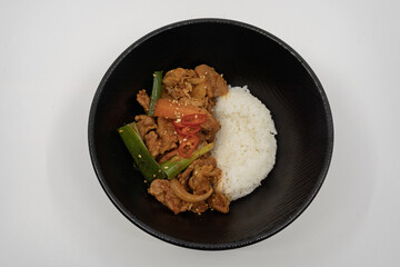 검은 그릇에 담긴 매콤한 제육덮밥

