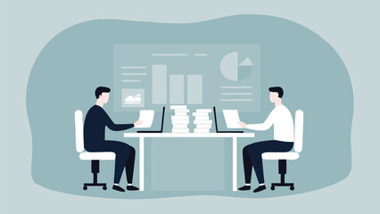 Two people working at desks with laptops and a stack of papers in front of a chart background