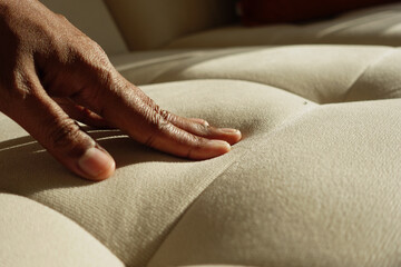 Hand pressing sofa in bright sunlight