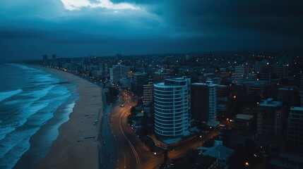 Coastal city skyline at twilight, lit by streetlights.
