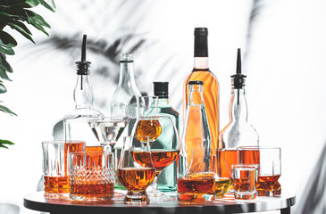 Collection of strong alcoholic drinks displayed on a table with various glassware and bottles in a vibrant setting