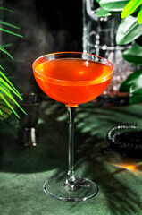 Savor the unique flavors of a naked and famous cocktail, a refreshing blend of mezcal and citrus, served in an elegant glass at a stylish venue.
