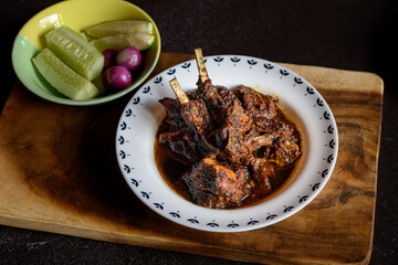 Traditional Bengali-style mutton kosha served in a small white bowl – spicy Indian goat curry, authentic Bengali kosha mangsho, slow-cooked meat dish, homestyle mutton curry, rustic overhead view