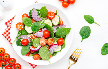 Vegan vegetable fresh salad with spinach, tomatoes, cucumber, onion, sesame and olive oil