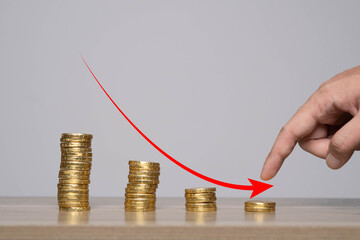 A hand points towards a stack of coins, illustrating financial growth or investment decisions in a...