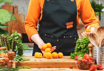 Cooking healthy vegan meals with apricots and fresh vegetables in a stylish kitchen to inspire a...
