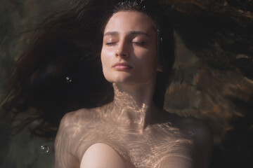 Peaceful Woman Floating In Water With Eyes Closed Under Soft Sunlight