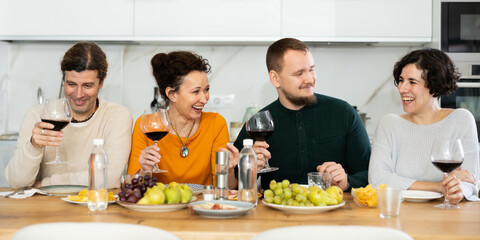 Friends are sitting at table, chatting sweetly, discussing and telling news, sharing plans. Married...