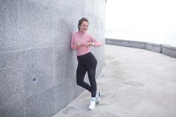 A sporty girl is dressed in sport clothes, leggins and rush guard doing sport exercises outside...