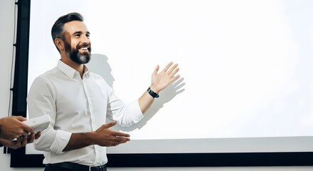 Confident businessman giving a presentation in a meeting. Professional speaker explaining a concept, gesturing at a blank white screen for copy space.